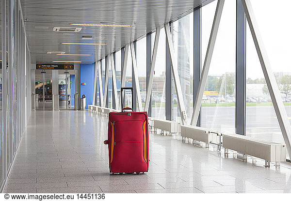 Suitcase in empty airport corridor