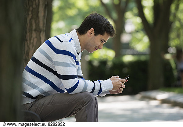 Summer. Business People. A Man Checking His Smart Phone For Messages.