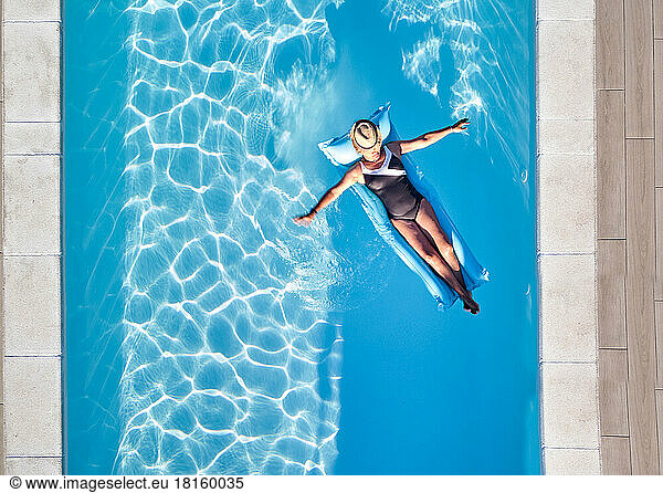 Summer Holidays  Calm Woman Floating In Swimming Pool