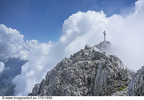 Summit cross on mountain top against cloudy sky  Bergamasque Alps  Italy