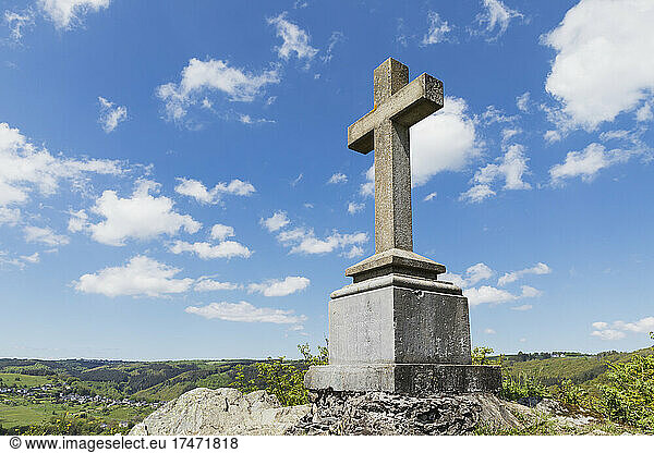 Summit Cross on rock under sky in Simmerath  Eifel  North Rhine Westphalia  Germany