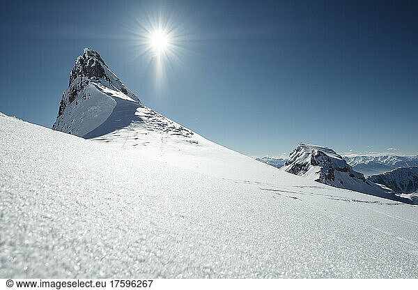 Sun shining over snowcapped peak in Rofan Mountains
