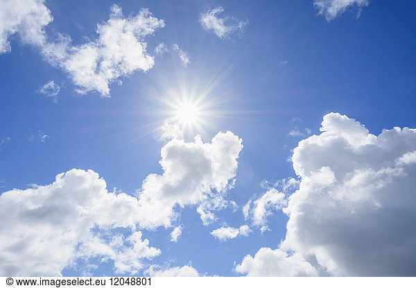 Sun shining through cumulus clouds in a sunny sky over Mallaig in Scotland  United Kingdom