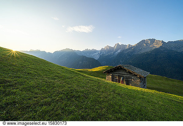 Sunburst on meadows and hut  Tombal  Soglio  Switzerland