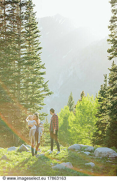 Sunflare over family with pine trees and mountains