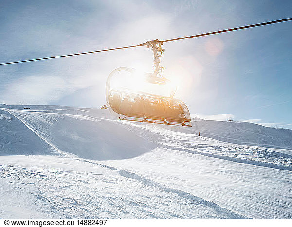 Sunlit ski lift in snow covered mountain landscape  Alpe Ciamporino  Piemonte  Italy