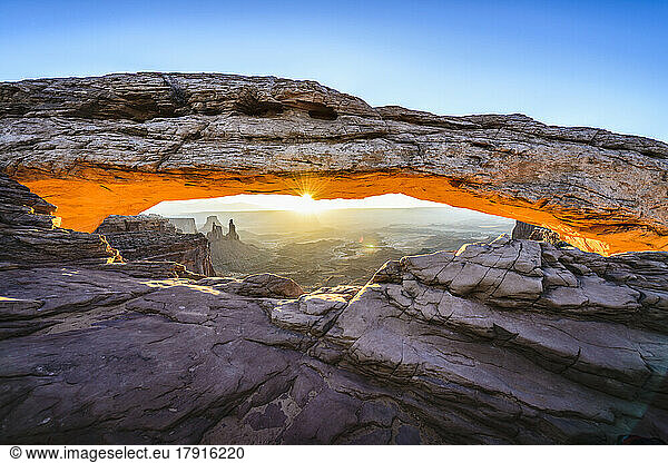 Sunrise at Mesa Arch in Canyonlands National Park at sunrise  the sun lighting the glowing sandstone underside of the arch.