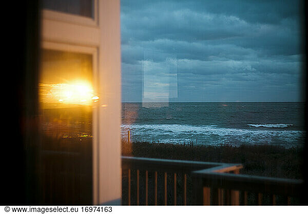 Sunrise is reflected in the windows overlooking the ocean