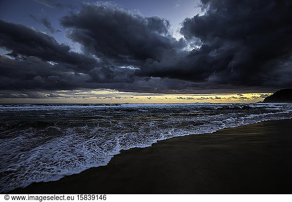 Sunset at the beach with heavy clouds