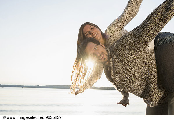 Sunset fun woman riding piggyback man