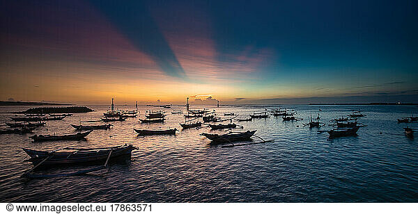 Sunset in Jimbaran bay in Bali with fishing boats