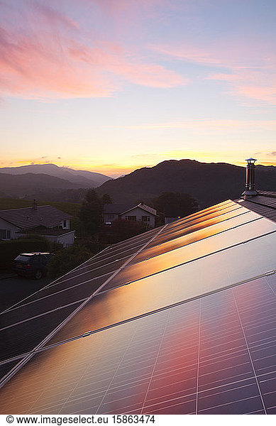 Sunset over a house in Ambleside  Lake District UK  with a 3.8 Kw solar electric panel system on the roof.