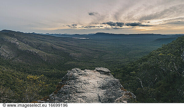 Sunset over the Grampians misty valley and lush forest from the top of a view point  Victoria  Australia