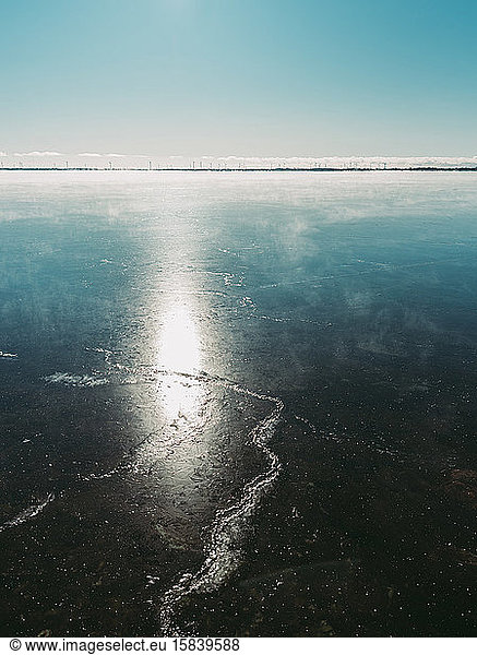 Sunshine hitting the ice of frozen Canadian lake on a winter day.