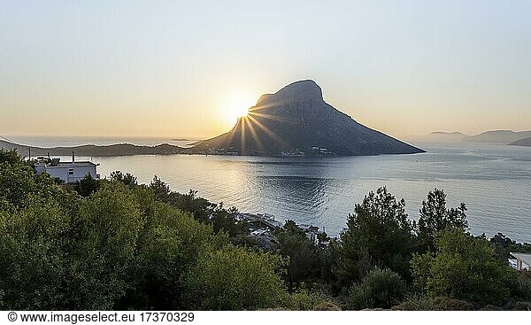 Sunshine over sea and hills in evening mood  village view of Mirties and Masouri  left Telendos Island  Kalymnos  Dodecanese  Greece  Europe