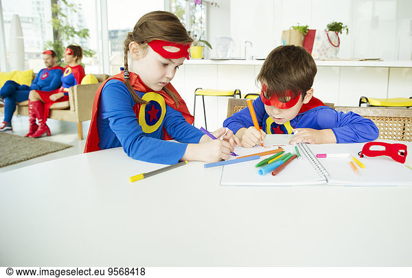 Superhero children drawing at table