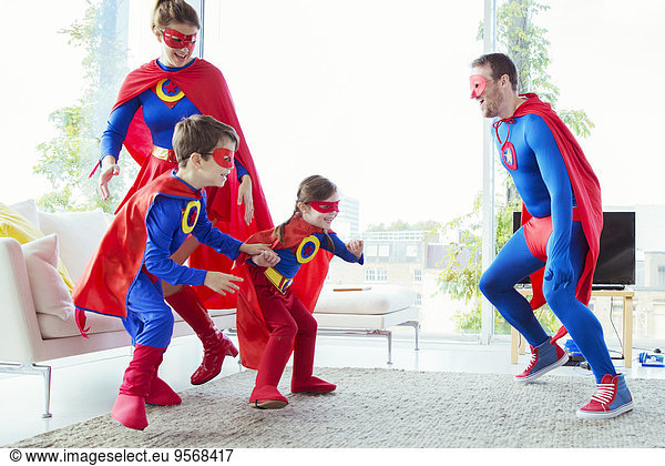 Superhero family chasing each other in living room