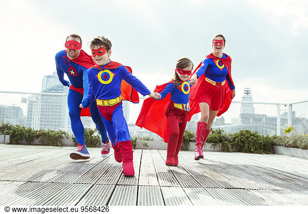 Superhero family playing on city rooftop
