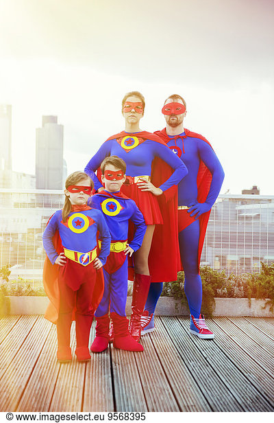 Superhero family standing on city rooftop
