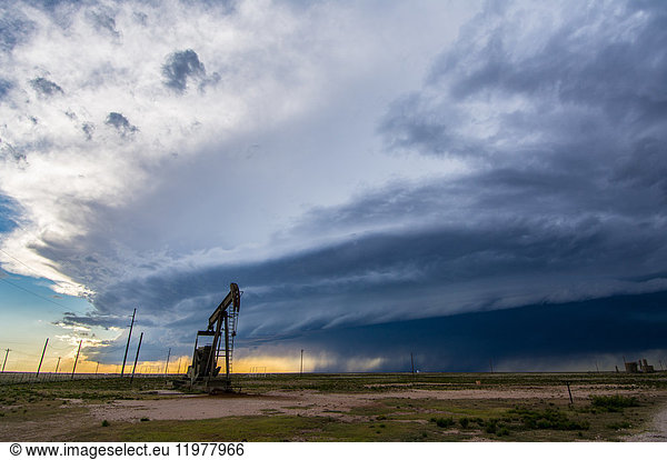 Superzellen-Gewitter droht hinter einer Ölpumpe über der Wüstenlandschaft von New Mexico  USA