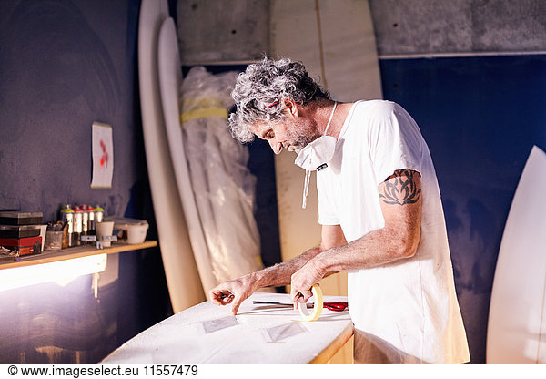 Surfboard-Designer beim Taping des Surfboards in der Werkstatt