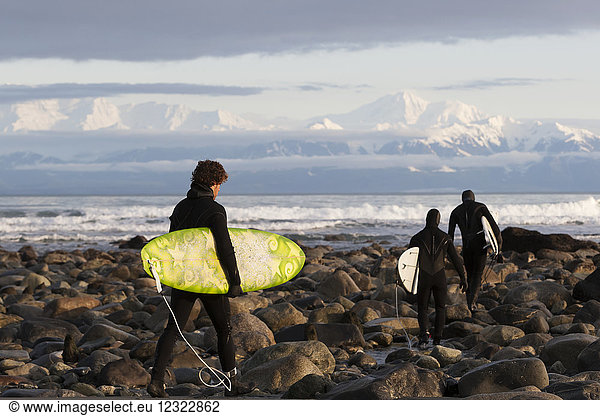 Surfer am felsigen Strand mit Fairweather Range im Hintergrund  Südost-Alaska; Yakutat  Alaska  Vereinigte Staaten von Amerika