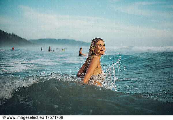surfer girl playing with the waves on the ocean