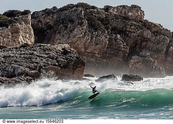 Surfer in the surf off the rocky coast  Portugal  Europe