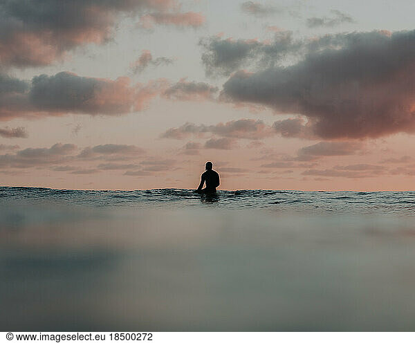 Surfer soaking in the beautiful ocean views at sunrise