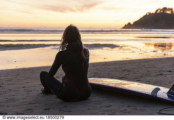 Surfer taking in the sunset along the Oregon coast