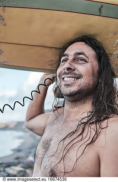 Surfer With Long Hair And Surfboard On His Head