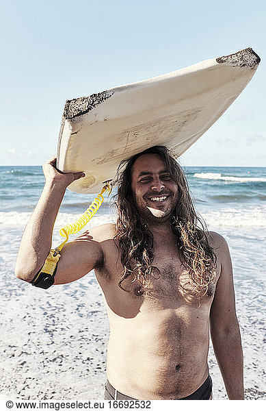 Surfer With Long Hair And Surfboard On His Head