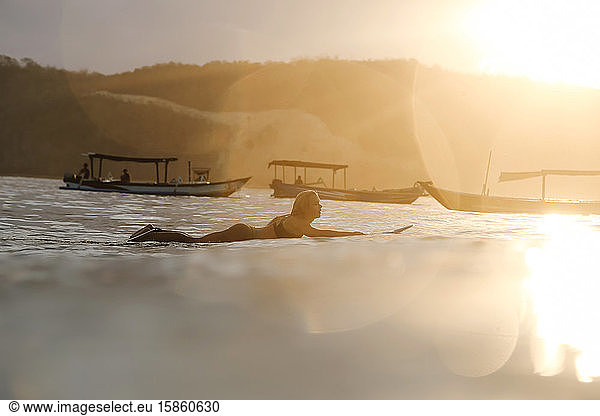 Surferin im Ozean bei Sonnenuntergang