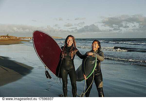 Surfers holding hands standing with surfboards at beach  Gran Canaria  Canary Islands