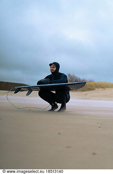 surfing in Kamchatka. Man in a wetsuit with a surfboard on the s