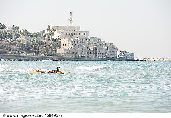 Surfs up as a female surfer heads into the waves in Israel