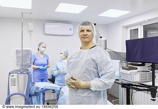 Surgeon with colleagues in illuminated operating room