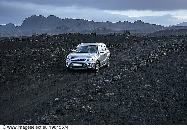 SUV driving along dirt road in volcanic landscape  Sprengisandsleid  Iceland