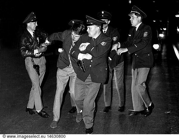 SW SG  Polizei  MÃ¼nchen  Schwabinger Krawalle  Demonstrationen  Polizisten fÃ¼hren Tillmann Bloem ab  Polizist durch Bild der KÃ¶rperverletzung Ã¼berfÃ¼hrt  21.6.1962 SW SG, Polizei, MÃ¼nchen, Schwabinger Krawalle, Demonstrationen, Polizisten fÃ¼hren Tillmann Bloem ab, Polizist durch Bild der KÃ¶rperverletzung Ã¼berfÃ¼hrt, 21.6.1962,