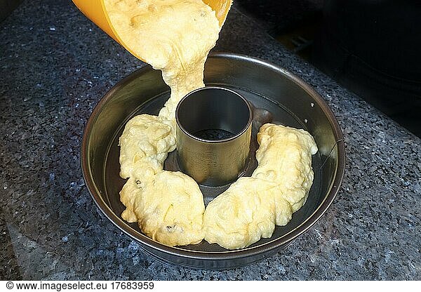 Swabian cuisine  preparation Swabian bundt  Swabian baking speciality  out of the oven  baked  filling sponge cake into baking tin  spring form  sweet cake  sweet  almonds  sultanas  pastry  traditional cuisine  food photography  studio  Germany  Europe