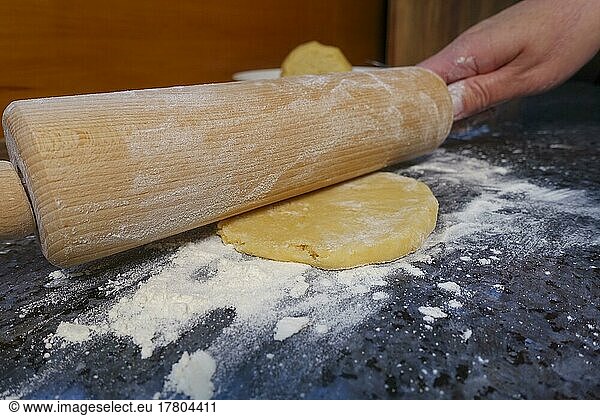 Swabian cuisine  preparing shortcrust pastry for hearty doughnuts  rolling out shortcrust pastry with a rolling pin  Kräpfle with sorrel  salty shortcrust pastry with yeast  out of the oven  baking  pastries  vegetarian  traditional cuisine  typical Swabian reinterpreted  party pastries  on the go  finger food  food photography  men's hand  studio  Germany  Europe