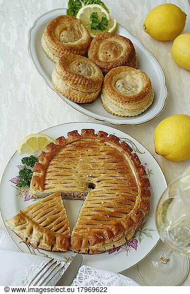 Swabian cuisine  Reutlinger Schiedwecken  puff pastry with veal filling  hearty pâté on plate  cutlery  knife  fork  lemons  parsley  bake  traditional Swabian dish  studio shot  food photography  Germany  Europe