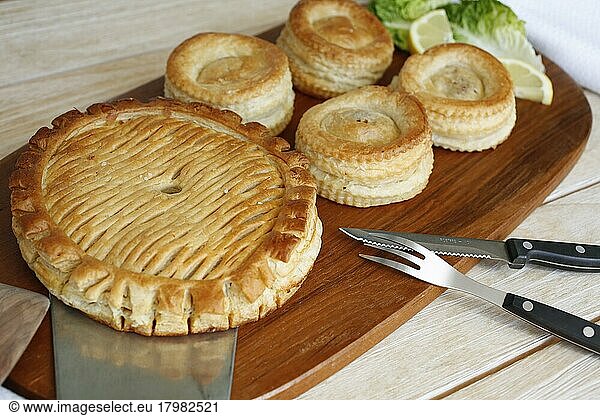 Swabian cuisine  Reutlinger Schiedwecken  puff pastry with veal filling  hearty pie on wooden board  cutlery  knife  fork  bake  traditional Swabian dish  studio shot  food photography  Germany  Europe
