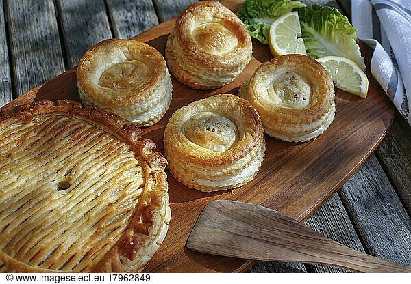 Swabian cuisine  Reutlinger Schiedwecken  puff pastry with veal filling  hearty pie on wooden board  spatula  bake  traditional Swabian dish  food photography  Germany  Europe