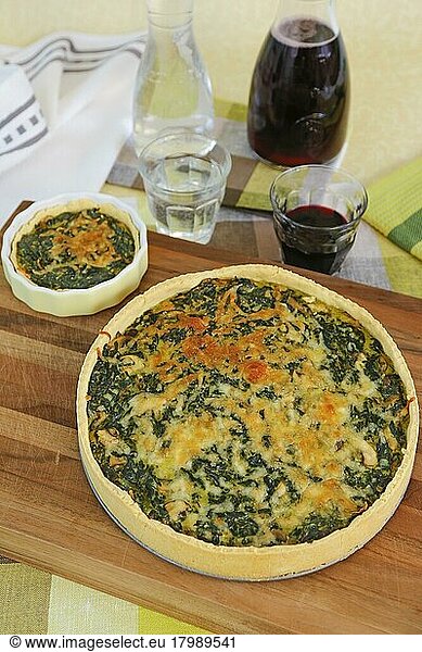 Swabian cuisine  spinach cake with shortcrust base  savoury cake  main course  bake  out of the oven  typical Swabian  vegetarian  healthy  traditional cuisine  water glasses  red wine  wooden board  carafes  food photography  studio  Germany  Europe