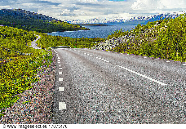Sweden  Norrbotten County  Asphalt road with lake and hills in background