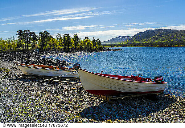 Sweden  Norrbotten County  Two motorboats left on lakeshore in summeron lake Akkajaure