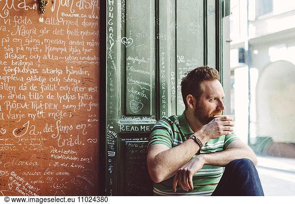 Sweden  Stockholm  Gamla Stan  Man holding coffee cup in cafe