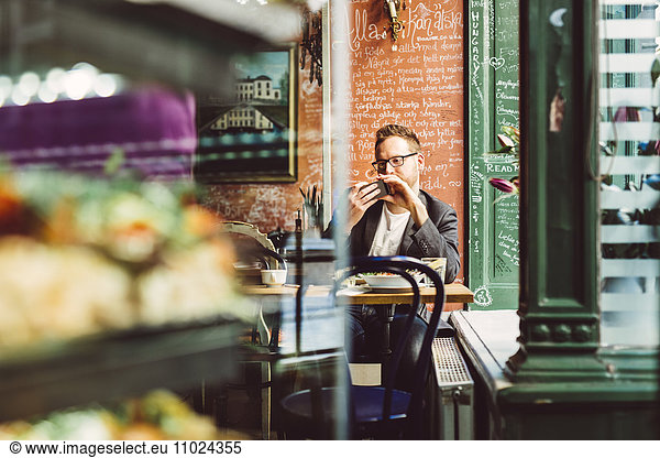 Sweden  Stockholm  Gamla Stan  Man using smartphone in cafe