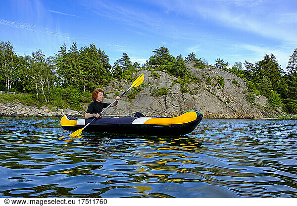 Sweden  Vastra Gotaland County  Kyrkesund  Teenage boy kayaking near coast of Lilla Askeron island